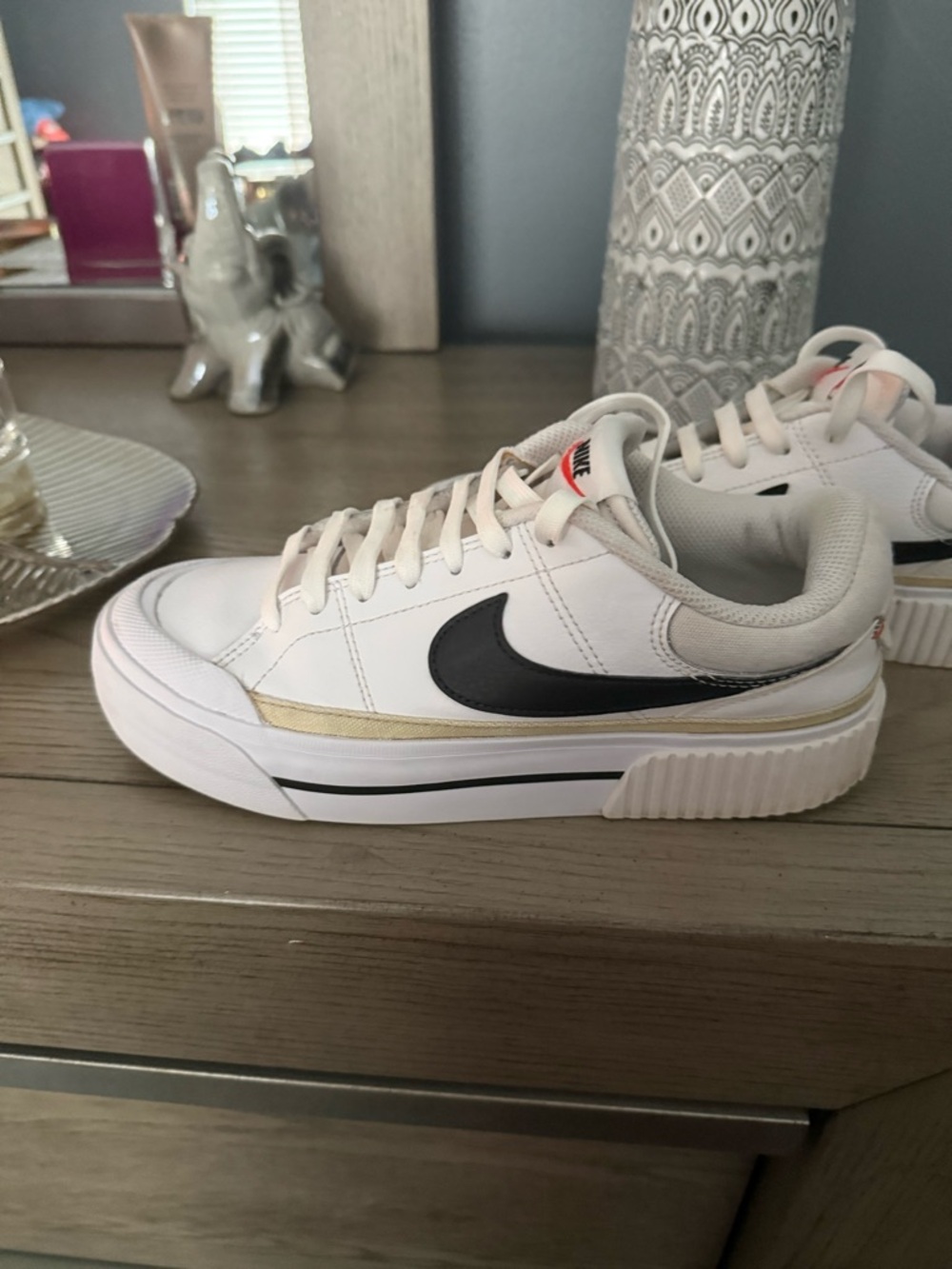 Nike White Low-Top Sneakers with Black Swoosh and Gold Accent